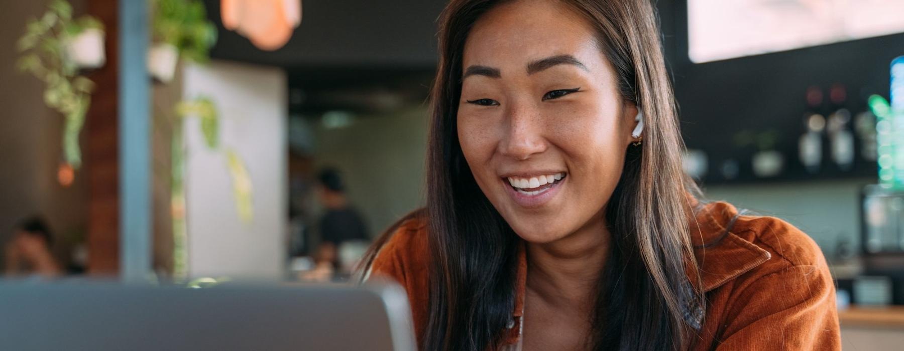 a woman smiling while working on laptop